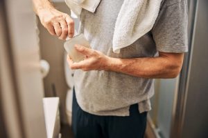 Man in the bathroom getting ready to apply a cleanser to his face