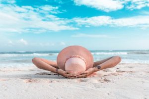 Woman laying on the beach under a blue sky